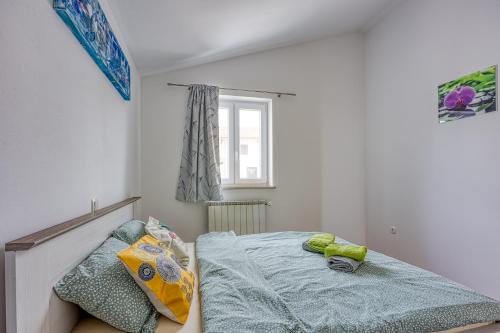 a small bedroom with a bed and a window at Family Apartment Marea in Nova Vas