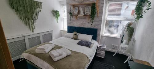 a bedroom with a bed with towels on it at The Hideaway Cottage Feel Patio Central Parking in Southport