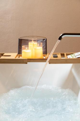 a bathtub with a candle and candles in it at Hotel Relais Des Glaciers - Adults Only in Champoluc