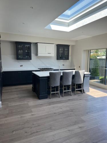 a kitchen with a kitchen island with chairs in it at Modern 4 bedroom house south Dublin in Blackrock