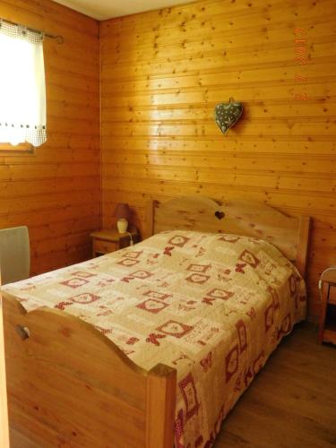 une chambre avec un lit dans une pièce en bois dans l'établissement Les Jonquilles, à Gérardmer