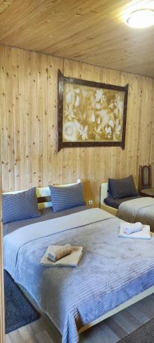 a bedroom with two beds and a painting on the wall at Diamond De Luxe in Kolomyya