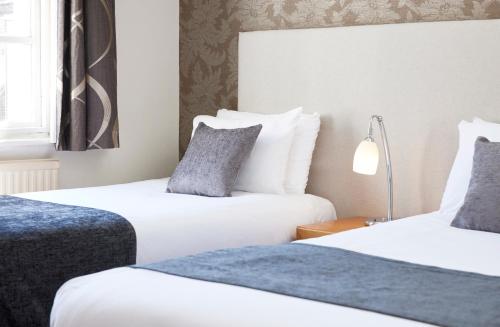 a hotel room with two beds and a window at Sun Hotel by Greene King Inns in Hitchin