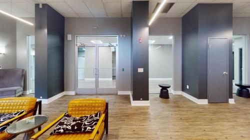 an empty room with two chairs and tables and doors at Avenue B846 2br, With A Pool, Gym, Parking in Philadelphia