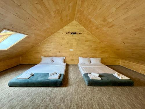 two beds in a room in a attic at Casa Tinca 2 in Izvoru Mureşului