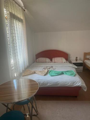 a bedroom with a bed with a table and a tableablish at Guest House Kollata in Vusanje