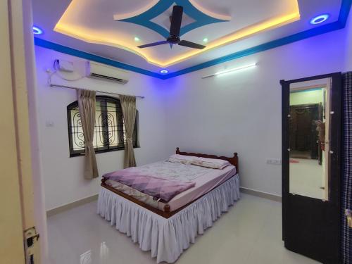 a bedroom with a bed with a blue ceiling at Serene Homestay in Panaji
