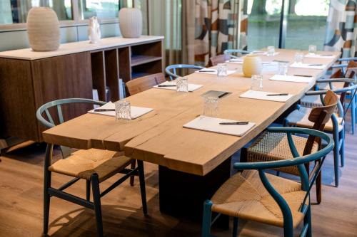 a long wooden table and chairs in a room at Motel One Rostock in Rostock