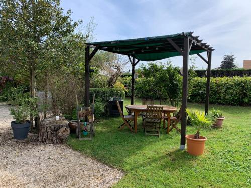 a picnic table under a canopy in a garden at Studio à 15mn de Beaune in Saint-Loup-Géanges