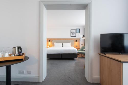 a hotel room with a bed and a television at Holiday Inn - Glasgow Airport by IHG in Paisley