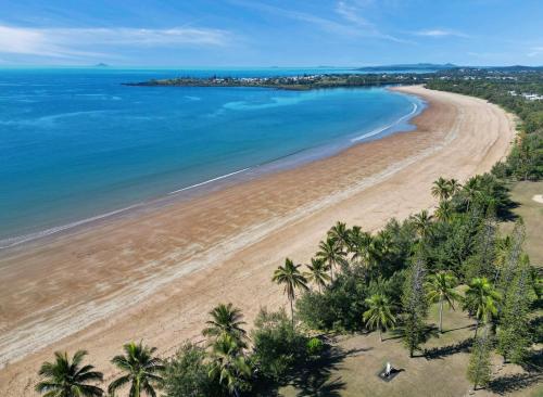 an aerial view of a beach with palm trees and the ocean at Iluka Palms in Grasstree Beach