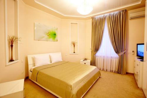 una camera d'albergo con letto e TV di Ultra Central Park Apartments a Chişinău