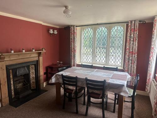 a dining room with a table and chairs and a fireplace at Trowbridge Lodge in Trowbridge