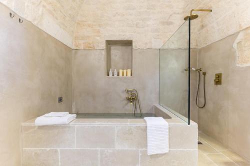 a bathroom with a shower and a bath tub at Casetta Wilma by Wonderful Italy in Cisternino