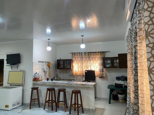 Una cocina con encimera y taburetes en una habitación. en House Chidenguele, en Chidenguele