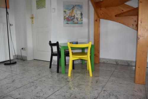 a green table and two yellow chairs in a room at Ferienhaus Achtern Diek 66 Burhave in Butjadingen