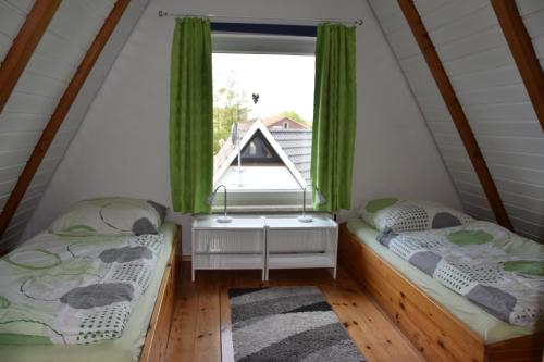 two beds in a room with a window at Ferienhaus Achtern Diek 66 Burhave in Butjadingen