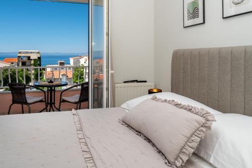 a bedroom with a bed with a view of the ocean at ROSSA Apartment in Tučepi