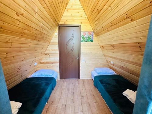 a room with two beds in a wooden room at Villa Wood in Mestia N 2 in Mestia