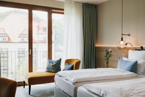 a hotel room with two beds and a window at AMERON Neuschwanstein Alpsee Resort & Spa in Schwangau