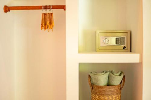 a bathroom with a shelf with a clock and a basket at Portales del Tayrona Garden Hotel in Calabazo