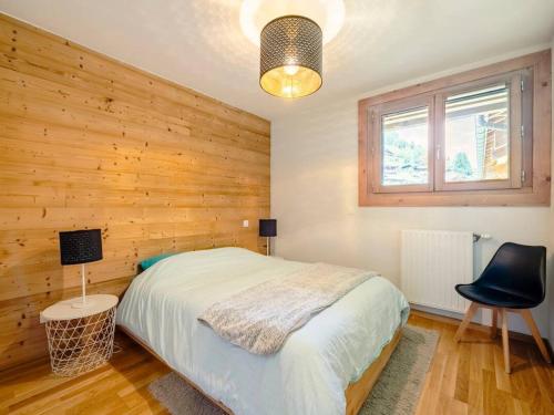 - une chambre avec un lit et un mur en bois dans l'établissement Spacieux appartement avec Wi-Fi et garage - FR-1-671-241, aux Gets