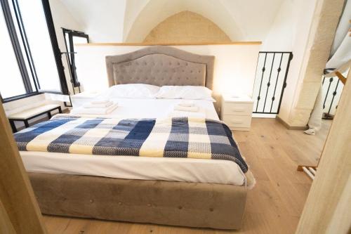 a bedroom with a bed with a blue and white blanket at Casa Margherita by Rentbeat in Melpignano