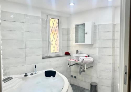 a white bathroom with a tub and a sink at Jacuzzi con Vista Favelas - Il Tuo Rifugio Esotico Urbano in Velletri
