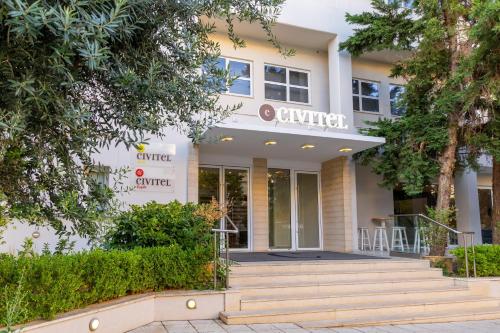 a building with stairs and trees in front of it at Civitel Attik Rooms & Suites in Athens