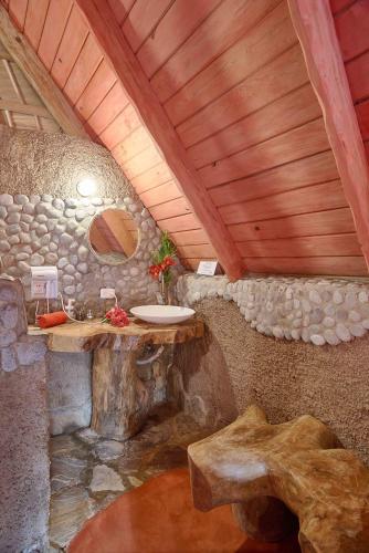 a bathroom with a sink in a stone wall at CHALET TROPICAL Hotel & Restaurant-Pizzeria in Las Galeras