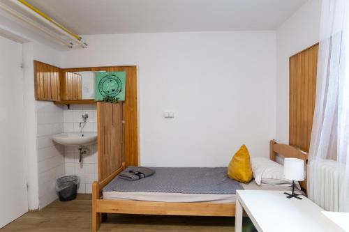 a small bedroom with a bed and a sink at Emona Guesthouse Ljubljana in Ljubljana