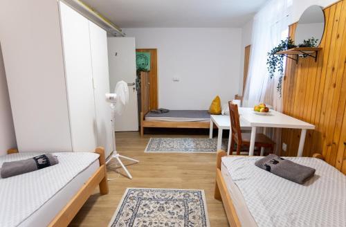 a room with two beds and a table and a dining room at Emona Guesthouse Ljubljana in Ljubljana