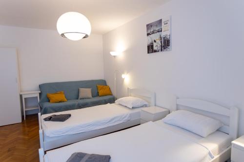 a bedroom with two beds and a couch at Emona Guesthouse Ljubljana in Ljubljana
