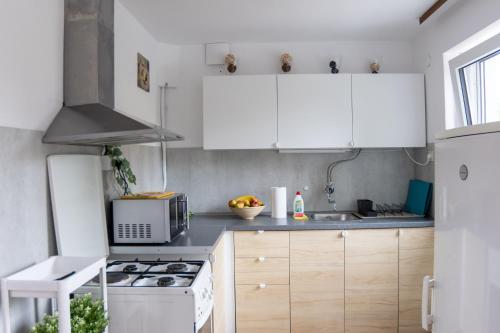 a kitchen with white cabinets and a stove top oven at Emona Guesthouse Ljubljana in Ljubljana