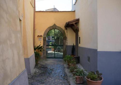an alley with a gate in a building with potted plants at Jacuzzi con Vista Favelas - Il Tuo Rifugio Esotico Urbano in Velletri