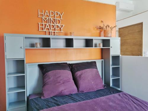 - un lit avec des oreillers violets dans une chambre dans l'établissement Le nid Etoilé Studio privatif, aux Arcs-sur-Argens