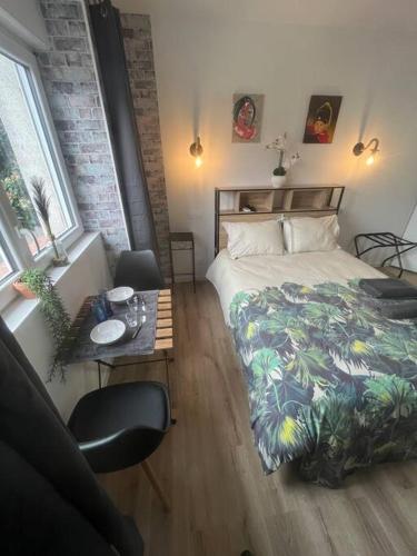 une chambre avec un lit, une table et des fenêtres dans l'établissement BACH studio BALNEO au calme parking gratuit, à Chasse-sur-Rhône