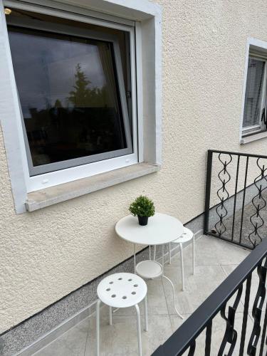a balcony with two chairs and a table and a window at Emona Guesthouse Ljubljana in Ljubljana