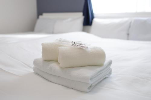 a pile of towels sitting on top of a bed at Rana片瀬江ノ島 in Fujisawa