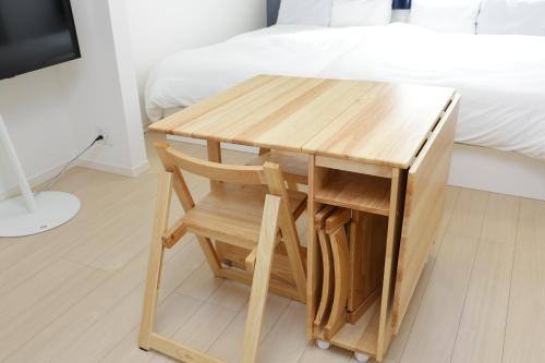 a wooden table with a chair next to a bed at Rana片瀬江ノ島 in Fujisawa