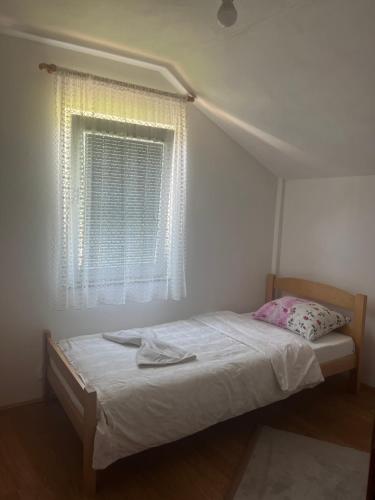 a bed in a room with a window and a bedvisor at Guest House Kollata in Vusanje