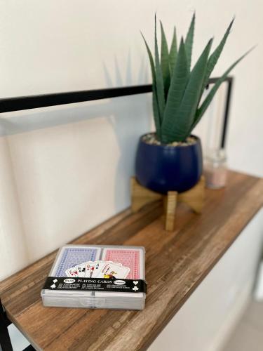 un livre et une plante en pot sur une table en bois dans l'établissement Appartement Moderne, proche Porte de Versailles et Gare de Clamart, à Malakoff