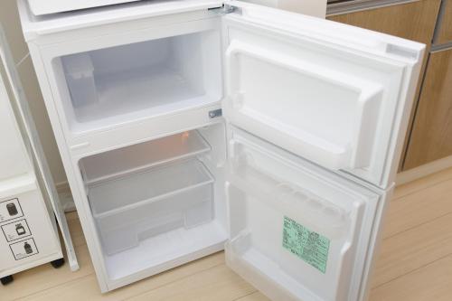 an empty refrigerator with its door open in a kitchen at Rana片瀬江ノ島 in Fujisawa