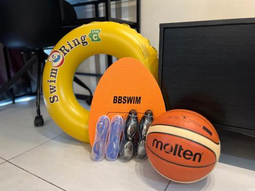 a group of shoes and a ball next to a yellow equipment at Georgetown Skypool Urban 3BR Family & Baby-Friendly 9pax Seaview Penang in Jelutong