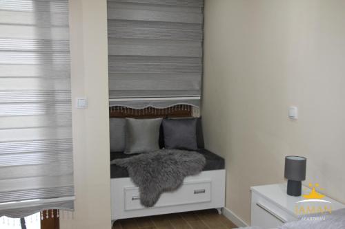 a small bedroom with a bed with a mirror at Apartman Jaman - Novi Pazar in Novi Pazar