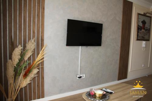 a living room with a television on a wall at Apartman Jaman - Novi Pazar in Novi Pazar