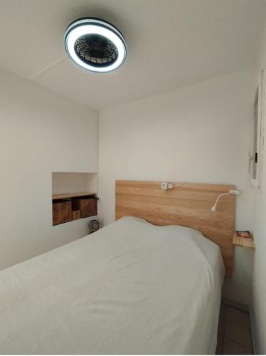 une chambre avec un lit et une lumière sur le mur dans l'établissement Rez-de-jardin climatisé, à La Londe-les-Maures