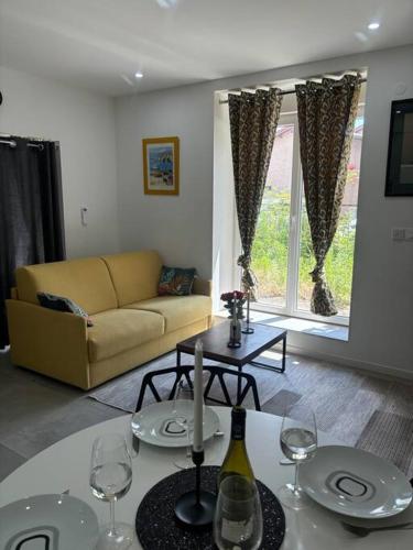 - un salon avec un canapé et une table avec des verres à vin dans l'établissement Mozart Cosy Love room, à Chasse-sur-Rhône