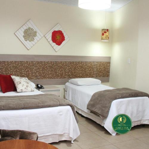 a hotel room with two beds in a room at Hotel Gaucha in Guaíra
