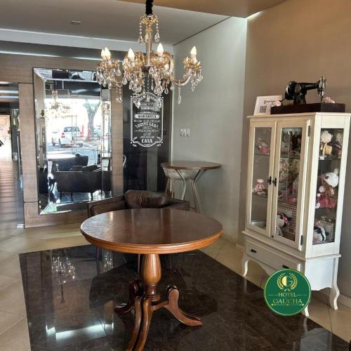 a dining room with a table and a chandelier at Hotel Gaucha in Guaíra